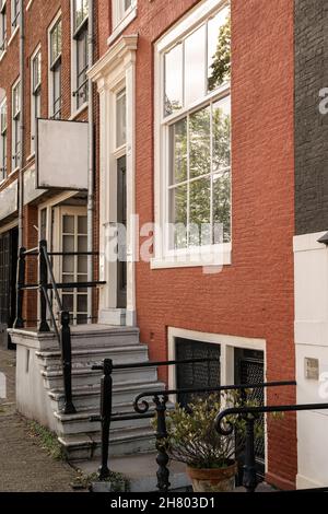 Porche avec balustrade métallique de bâtiment résidentiel avec fenêtres et façade en briques situé sur la rue dans le quartier de la ville Banque D'Images