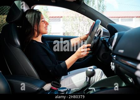 jeune femme latine conduisant une voiture de luxe Banque D'Images