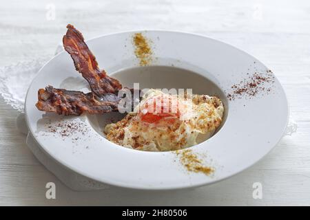 Vue en hauteur des œufs savoureux avec des tranches de bacon frites sur l'assiette Banque D'Images