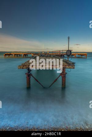 ancienne jetée abandonnée sur la côte de l'île de wight, rive de l'île de wight à la baie de totland, jetée ancienne rouillée ou jetée dans la lumière atmosphérique et mer calme. Banque D'Images