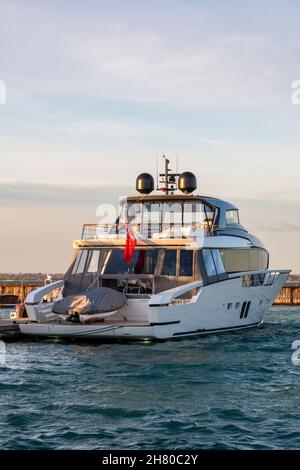 superyacht amarré dans le port de solent au coucher du soleil, lumière du soir au-dessus du port de yarmouth et yacht à moteur millionnaires sur l'île de wight dans la lumière du soir. Banque D'Images