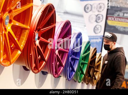 Essen, Allemagne.26 novembre 2021.Un visiteur professionnel regarde les jantes en alliage colorées pour régler les voitures au salon de l'auto d'Essen.Environ 400 exposants souhaitent présenter des véhicules et des accessoires dans huit halls de 27.11 à 05.12.2021.Crédit : Roland Weihrauch/dpa/Alay Live News Banque D'Images