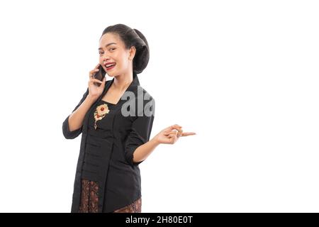 femme dans kebaya présentant l'espace de copie tout en appelant Banque D'Images