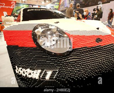 Essen, Allemagne.26 novembre 2021.Une Porsche 911 RSR, dont la moitié du corps est faite de briques Lego, est photographiée par un visiteur professionnel au salon de l'tuning 'Essen Motor Show'.Environ 400 exposants souhaitent présenter des véhicules et des accessoires dans huit halls de 27.11 à 05.12.2021.Crédit : Roland Weihrauch/dpa/Alay Live News Banque D'Images