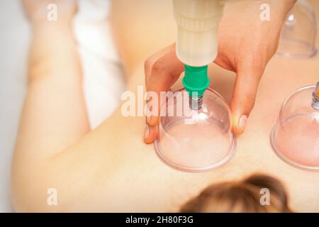 Femme recevant un traitement par immersion sous vide sur le dos couché sur la poitrine dans le salon de massage Banque D'Images