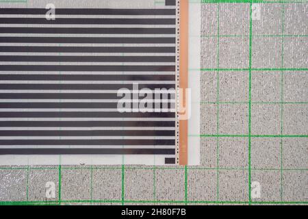 Un rouleau de film sous le plancher chauffant repose sur l'isolation Banque D'Images