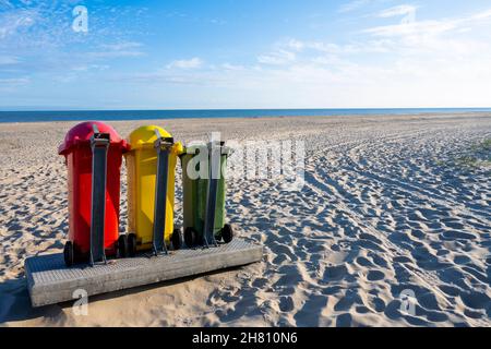 Bacs séparateurs pour le recyclage des déchets jaunes, rouges et verts sur la plage par beau temps Banque D'Images