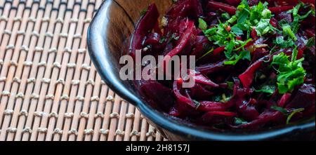 Beetroot grillé au persil et à l'ail dans une assiette de verre sur Placemat bambou gros plan point de vue lumière douce Banque D'Images