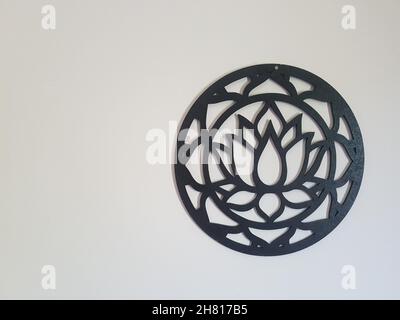 Fleur de Lotus dans un mandala en bois noir sur un mur blanc avec espace pour le texte. Banque D'Images