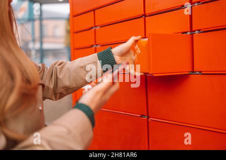 Femme cliente utilisant un terminal de poste automatisé en libre-service ou un casier le matin Banque D'Images