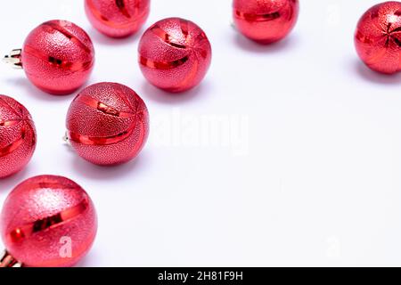 Boules de Noël rouges dispersées sur fond blanc.Carte de Noël.Photo horizontale. Banque D'Images