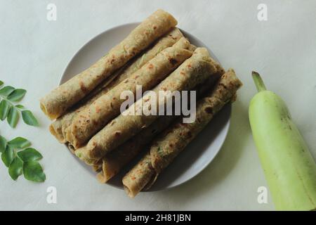 Pain plat indien fait de farine de blé entier, garde de bouteille râpé, yaourt et épices.Communément appelé lauki paratha en Inde.Prise de vue sur fond blanc Banque D'Images