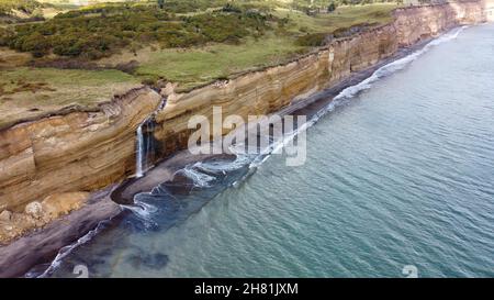 Cascade sur la falaise de Golovinsky sur l'île de Kunashir, îles Kuril, Russie.Photographie aérienne. Banque D'Images