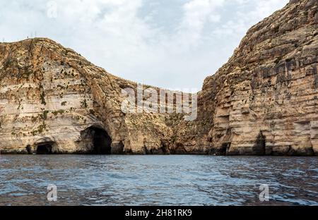 Bords rocailleux de la crique de iż-Żurrieq, près de la Grotte bleue, Malte, sortant de la mer Méditerranée et éclairé par le soleil du matin.Formations rocheuses avec Banque D'Images