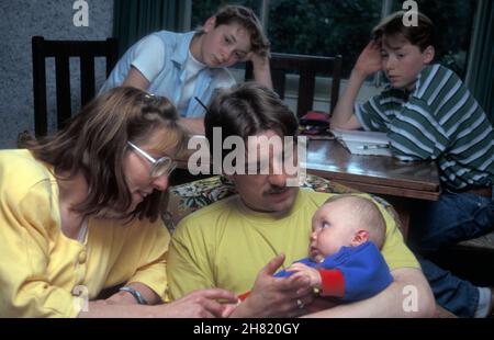 famille caucasienne dans le logement social avec nouveau bébé et jeunes frères et sœurs Banque D'Images