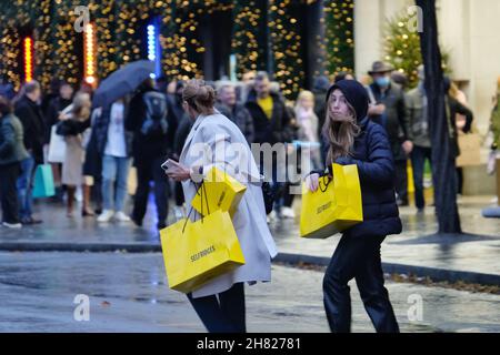 Londres, Royaume-Uni, 26 novembre 2021.Les détaillants d'Oxford Street et de Regent Street reçoivent un coup de pouce le Black Friday, car les acheteurs chargés de sacs d'achats festifs semblaient déterminés par la grève du métro de transport for London qui touche cinq lignes de métro jusqu'à dimanche matin.Les magasins de Regent Street et d'Oxford Street ont commencé lentement mais l'après-midi, les gens étaient très animés.Crédit : onzième heure Photographie/Alamy Live News Banque D'Images