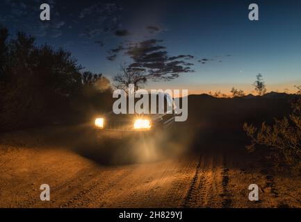 Jeep Grand Cherokee hors route la nuit, phares allumés. Banque D'Images