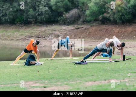 Instructeur de yoga menant un cours de yoga dans un parc Banque D'Images