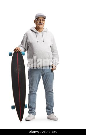 Portrait en longueur d'un homme mûr gai avec un capuchon et un sweat à capuche tenant un skateboard isolé sur fond blanc Banque D'Images