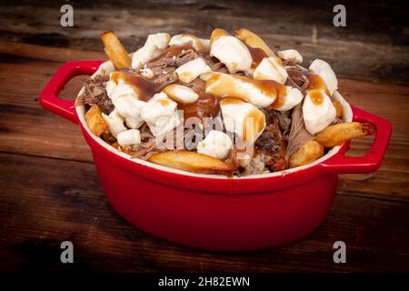 la coutine de confit de canard sur une table en bois est un repas canadien préparé avec de la sauce aux frites et des carets de fromage Banque D'Images