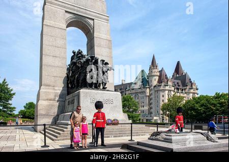 Ottawa, Canada - le 2 juillet 2011 : les touristes posent avec des gardes cérémoniels au monument commémoratif de guerre de Cenotaph à Ottawa.Le Château Laurier est visible à l'arrière-plan Banque D'Images