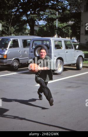 OCEAN SPRINGS, ÉTATS-UNIS - 22 novembre 2021 : l'homme court avec le basket-ball à travers le parking pour faire un cerceau Banque D'Images