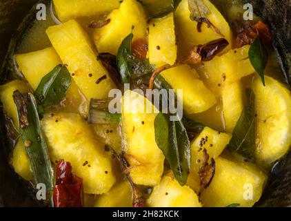 plat au manioc ou au manioc, également connu sous le nom de manioc, yuca ou arrowroot brésilien, préparé avec des piments rouges, des feuilles de curry et des graines de moutarde, en gros plan Banque D'Images