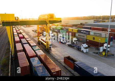 Vue aérienne d'un terminal de trains de conteneurs très fréquenté à Leeds avec des caisses d'expédition attendant d'être chargées sur la file d'attente et le transport de fret ferroviaire Banque D'Images