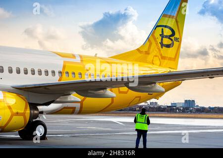 Avion jaune de la compagnie aérienne Bees sur le tablier.Boeing 737-800 UR-UBA avion de tourisme.Après la pluie et le lavage.Copier piste d'espace.Ukraine, Kiev - 19 mars 2021. Banque D'Images