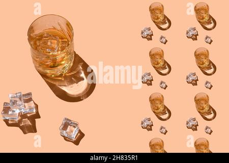 Glasse avec boissons alcoolisées fortes, liqueurs dures, spiritueux et distillats en verres avec glaçons : cognac, scotch, whisky.Motif boisson sur la pêche Banque D'Images