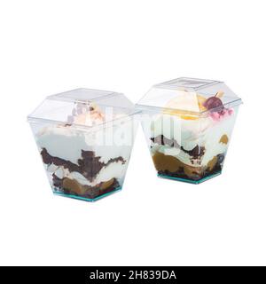 Dessert sucré ou crème glacée dans des tasses en plastique isolées sur fond blanc, photographie d'objet Banque D'Images