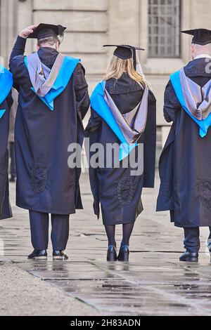 Des granduates couronnées de succès s'alignent dans la cour de Clarendon après la cérémonie de remise de leur diplôme au Sheldonian Theatre de l'université d'Oxford, le 26 novembre 2021, sur une peau humide. Banque D'Images