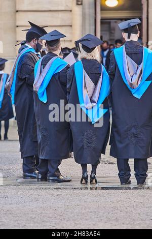 Des étudiants granduates couronnés de succès se font la queue dans la cour Bodleian après la cérémonie de remise de leur diplôme au théâtre Sheldonian de l'université d'Oxford, le 26 novembre 2021, sur une peau humide. Banque D'Images