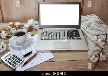 comptabilité automnale saisonnière, ordinateur portable avec maquette à écran blanc, calculatrice, document financier et une tasse de café sur une table rustique en bois avec du tissu en coton Banque D'Images