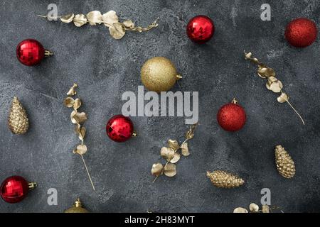 Les vacances sont encore en vie avec une décoration de Noël dorée et rouge sur fond sombre.Fêtes d'hiver.Flat lay, vue de dessus Banque D'Images
