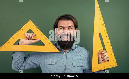 homme heureux avec la taille mesurée sur l'outil de mathématiques de règle de triangle, école de mathématiques Banque D'Images