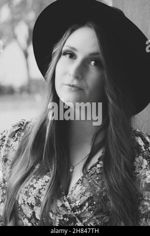 Prise de vue verticale en niveaux de gris d'une jeune femme caucasienne posant pour un photoshoot. Banque D'Images