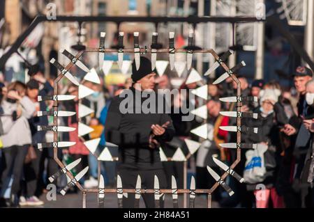 Glasgow, Écosse, Royaume-Uni.27 novembre 2021 : l'artiste de rue Liam Collins, connu sous le nom de Stunt Runner, interprète le théâtre de rue sur Buchanan Street pour divertir les amateurs de Noël.L'artiste est aveuglée puis court et saute à travers le travail de métal entouré de couteaux, pointes, dents de métal et flammes.Credit: SKULLY/Alay Live News Banque D'Images