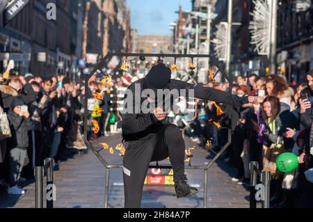 Glasgow, Écosse, Royaume-Uni.27 novembre 2021 : l'artiste de rue Liam Collins, connu sous le nom de Stunt Runner, interprète le théâtre de rue sur Buchanan Street pour divertir les amateurs de Noël.L'artiste est aveuglée puis court et saute à travers le travail de métal entouré de couteaux, pointes, dents de métal et flammes.Credit: SKULLY/Alay Live News Banque D'Images