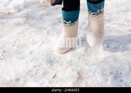 Bottes en feutre blanc avec ornement.Gros plan des pieds d'homme dans des bottes en feutre et debout sur de la neige fraîche qui est tombée après de fortes chutes de neige Banque D'Images