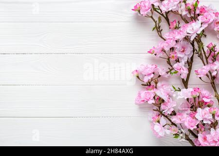Branches Sakura sur une table en bois.Fleur de cerisier rose sur fond de bois blanc.Bordure du cadre.Modèle avec espace de copie.Motif avec place pour le texte. Banque D'Images