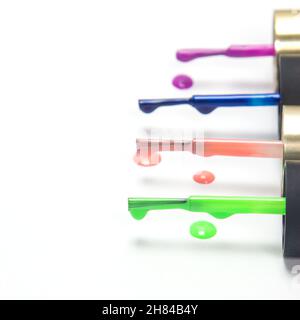 Brosses avec vernis à ongles multicolore l'une après l'autre sur fond blanc Banque D'Images