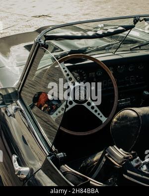 Une photo en grand angle de l'intérieur d'une voiture classique décapotable verte prise par une journée ensoleillée. Banque D'Images