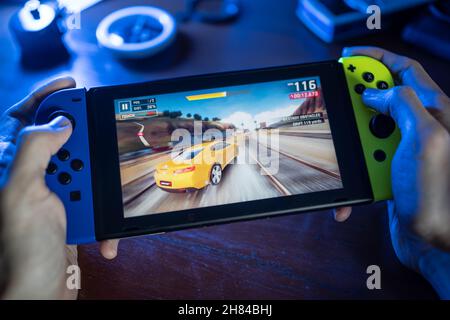 Bangkok, Thaïlande - 23 novembre 2021 : Gamer jouant à Asphalt 9, un jeu de course développé par Gameloft, sur Nintendo Switch. Banque D'Images