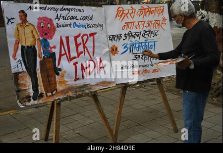 Mumbai, Inde.27 novembre 2021.Un homme portant un masque facial protecteur peint une affiche pour faire prendre conscience de la nouvelle variante du coronavirus qui a émergé en Afrique du Sud.la Brihanmumbai Municipal Corporation (BMC) comme mesure de précaution mettra en quarantaine les rapatriés d'Afrique du Sud à leur arrivée à Mumbai.(Photo par Ashish Vaishnav/SOPA Images/Sipa USA) crédit: SIPA USA/Alay Live News Banque D'Images