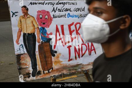 Mumbai, Inde.27 novembre 2021.Un homme portant un masque facial protecteur passe devant une peinture faite par l'école d'art de Gurukul pour faire prendre conscience de la nouvelle variante du coronavirus qui a émergé en Afrique du Sud.la Brihanmumbai Municipal Corporation (BMC) comme mesure de précaution mettra en quarantaine les rapatriés d'Afrique du Sud à leur arrivée à Mumbai.Crédit : SOPA Images Limited/Alamy Live News Banque D'Images