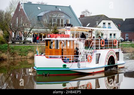 Carolinensiel, Allemagne.27 novembre 2021.Le bateau à aubes historique « Concordia II » navigue dans le port historique avec des lumières de Noël.Depuis 1995, un arbre de Noël flottant a été traditionnellement érigé et les lumières allumées à Carolinensiel le samedi précédant le premier dimanche de l'Avent.Credit: Hauke-Christian Dittrich/dpa/Alay Live News Banque D'Images