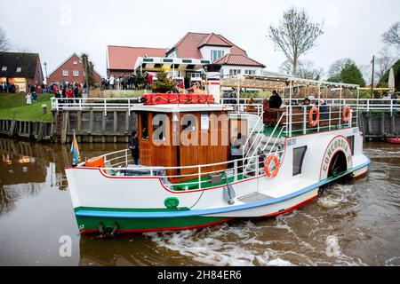 Carolinensiel, Allemagne.27 novembre 2021.Le bateau à aubes historique « Concordia II » navigue dans le port historique avec des lumières de Noël.Depuis 1995, un arbre de Noël flottant a été traditionnellement érigé et les lumières allumées à Carolinensiel le samedi précédant le premier dimanche de l'Avent.Credit: Hauke-Christian Dittrich/dpa/Alay Live News Banque D'Images