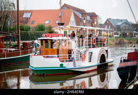 Carolinensiel, Allemagne.27 novembre 2021.Le bateau à aubes historique « Concordia II » navigue dans le port historique avec des lumières de Noël.Depuis 1995, un arbre de Noël flottant a été traditionnellement érigé et les lumières allumées à Carolinensiel le samedi précédant le premier dimanche de l'Avent.Credit: Hauke-Christian Dittrich/dpa/Alay Live News Banque D'Images