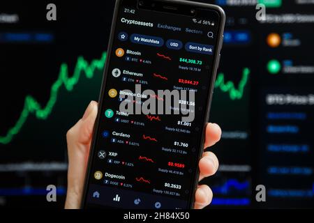 Ukraine, Odessa - octobre 9 2021 : main tenant mobile avec l'application CoinMarketCap fonctionnant sur l'écran de smartphone avec la liste des prix de crypto-monnaie actuels, Banque D'Images